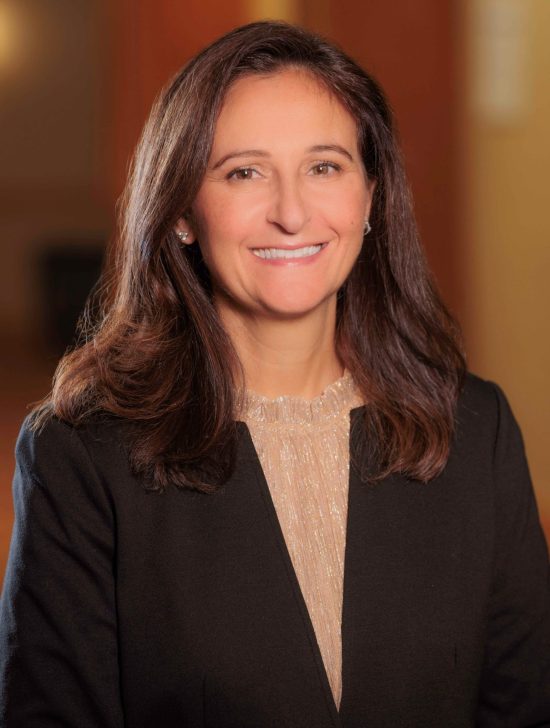 A woman in a business suit smiling for the camera.